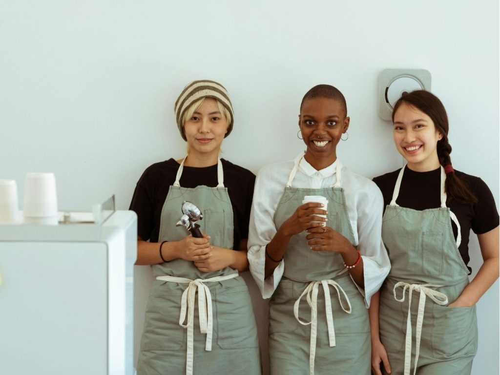 Delighted baristas with portafilter and paper