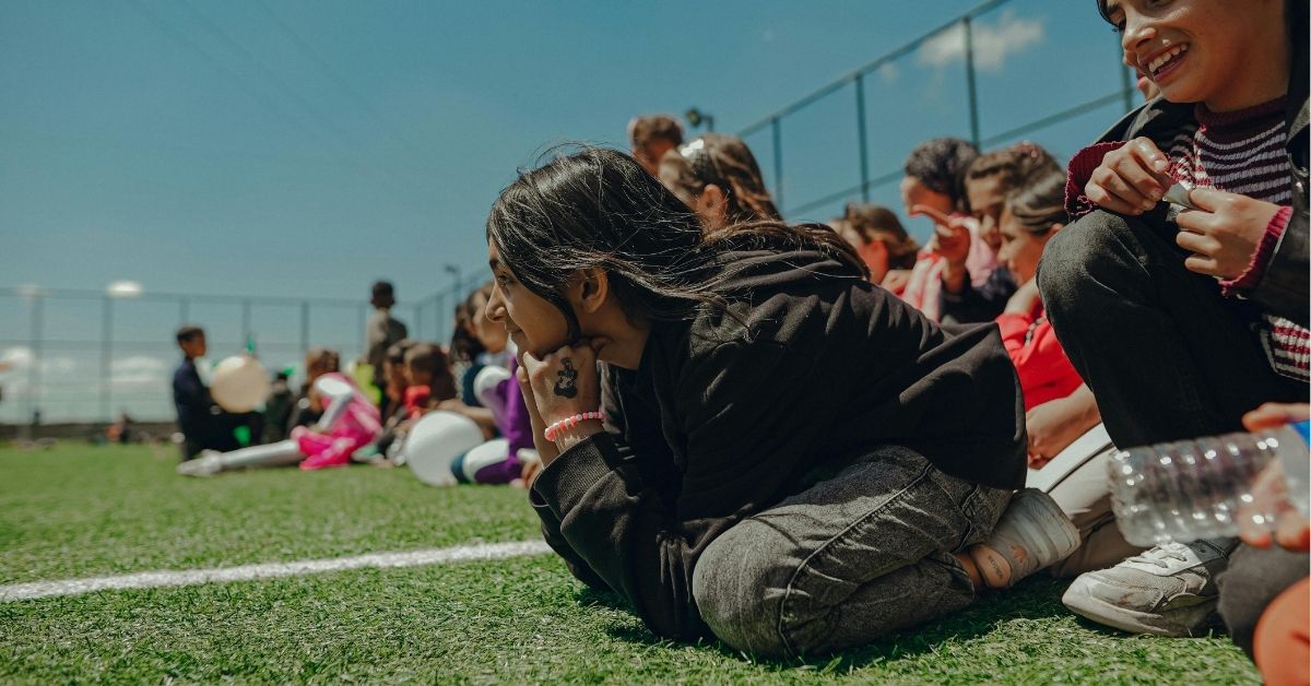 Smiling girls sitting on football field