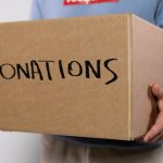 a volunteer carrying a box of donations