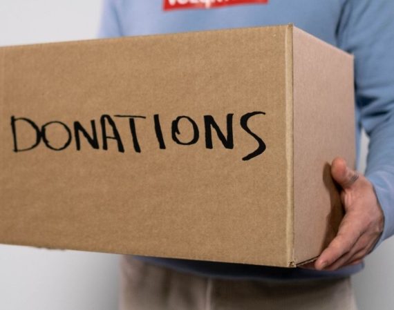 a volunteer carrying a box of donations