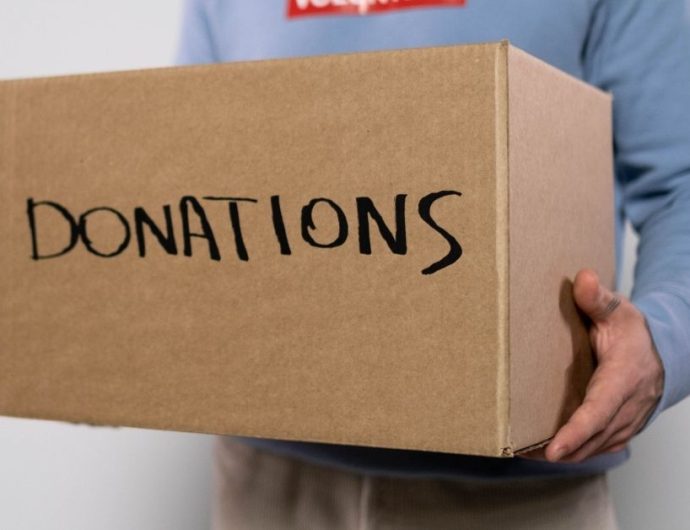 a volunteer carrying a box of donations