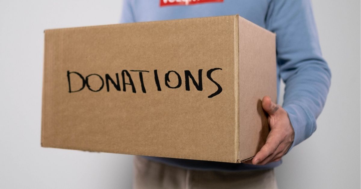 a volunteer carrying a box of donations